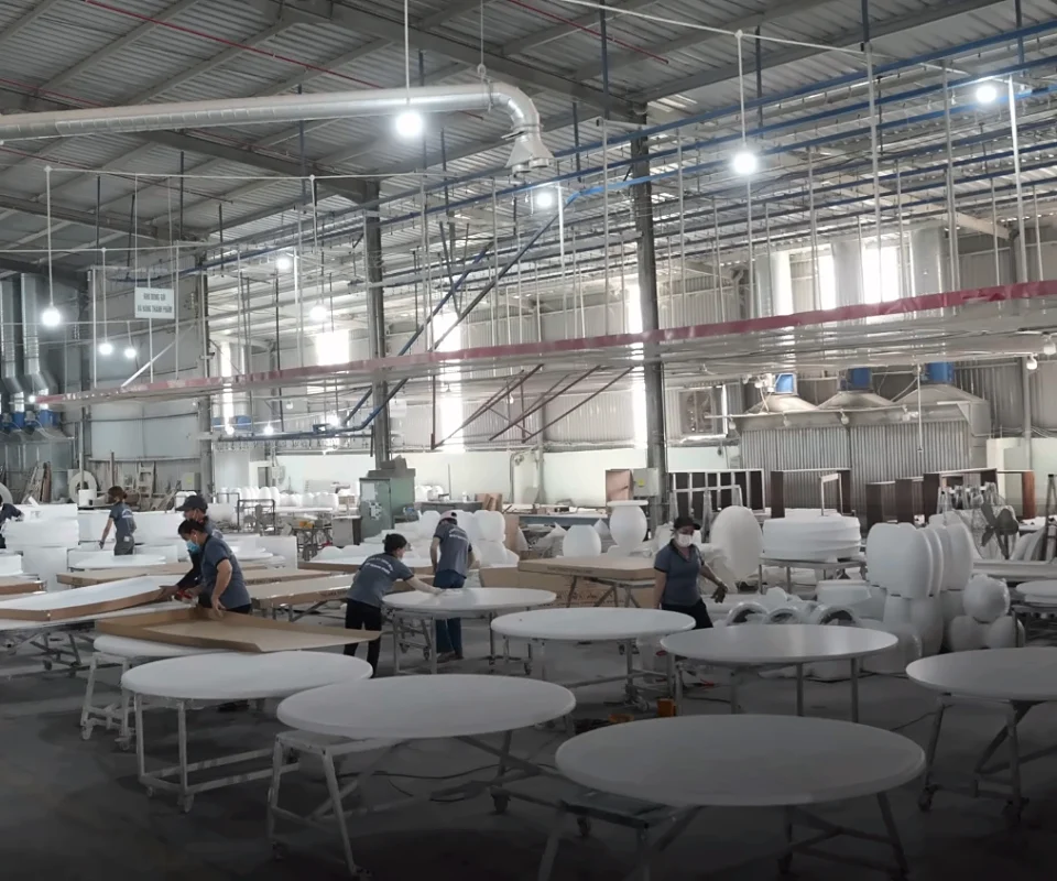 Production hall of the Q-Furniture factory with rows of round concrete table tops in finishing